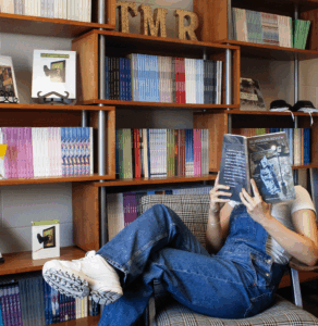 Immersive internships: student reads the Spring 2025 issue of the Missouri Review at TMR offices