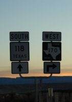 Two road signs at sunset