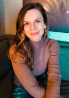 Author in brown turtleneck poses for a portrait