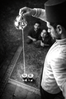 Black and white and photo of a man pouring tea from shoulder height